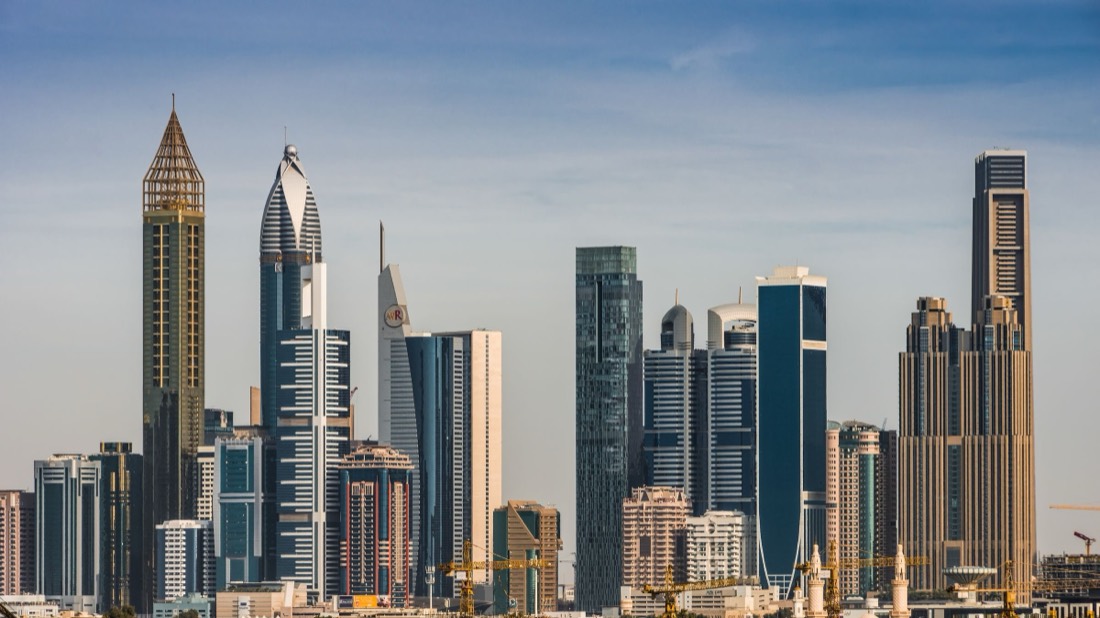 Dubai towers along Sheikh Zayed Road under a clear pale sky